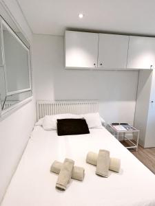 a bedroom with a white bed with two pillows on it at Stylish City Centre Studio - Grand Central House in Gibraltar