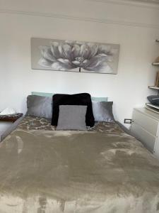 1 dormitorio con 1 cama con un cuadro de flores en la pared en Rose en Croydon