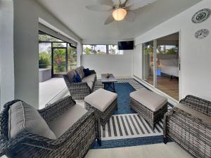 een woonkamer met rieten meubels en een plafondventilator bij Coastal Castaway in Cape Coral
