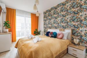 a bedroom with a large bed with a floral wall at Wellness & SPA Resort Dziwnów Apartments with Parking by Renters Prestige in Dziwnów