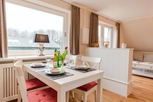a dining room with a white table and chairs at White House Ferienwohnung 2 in Alkersum