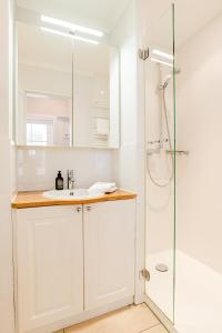 ein Bad mit einem Waschbecken und einer Dusche in der Unterkunft Haus Uthlande Wohnung 25 in Wyk auf Föhr