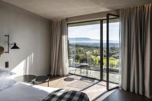 a hotel room with a bed and a large window at Puro Dão Hotel & Spa in Nelas