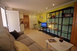 uma sala de estar com um sofá e uma mesa em wunderschönes kleines Apartment für 2 Personen mit idylischen Blick ins Grüne em Cala Galdana