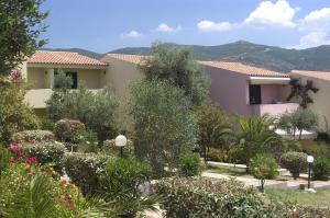 un edificio con un jardín con flores y árboles en Borgo del Tennis - Sa Ventana 2, en Badesi