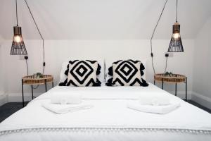a bedroom with a large white bed with two tables at Modern Cardiff Retreat 3BR with Netflix & High-Speed Wifi in Cardiff