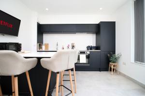 a kitchen with black cabinets and white appliances at Modern Cardiff Retreat 3BR with Netflix & High-Speed Wifi in Cardiff