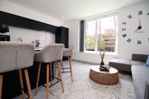 a living room with a table and a clock on the wall at Modern Cardiff Retreat 3BR with Netflix & High-Speed Wifi in Cardiff
