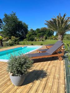 a wooden deck next to a swimming pool at Le Domaine d'Etaville in Sottevast