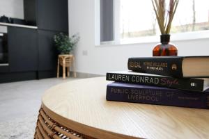 a stack of books sitting on top of a table at Modern Cardiff Retreat 3BR with Netflix & High-Speed Wifi in Cardiff