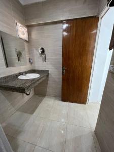 a bathroom with a sink and a wooden door at Lilly Rooms and Studio in Hurghada