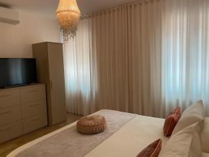 um quarto com uma cama, uma televisão e cortinas em MURANO Place - MISTRO House em Murano