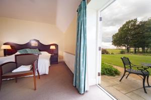Schlafzimmer mit einem Bett und einer Glasschiebetür in der Unterkunft Heacham Manor Hotel in Hunstanton
