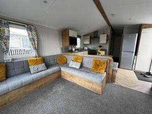a living room with a couch and a kitchen at Great 8 Berth Caravan With Decking At Valley Farm, Ref 46238pl in Great Clacton