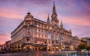 a large building on a city street at dusk at Stylish 2-Bedroom Apartment in Central Budapest in Budapest