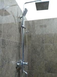 a shower with a shower head in a bathroom at Ella Shali's home in Ella