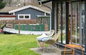 - deux chaises assises sur une terrasse couverte avec un bateau dans l'établissement Nice Home In Brkop With Wi-fi, à Børkop
