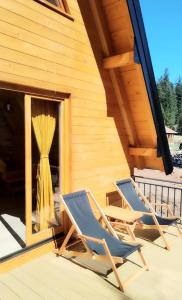 two chairs on the deck of a cabin at Planinska kuća Stašević in Mitrovac