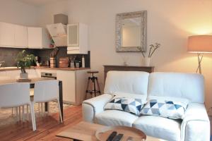a living room with a white couch and a kitchen at Hotegam agency, 70 rue Thiers Championnet, close SNCF, new & design, 2 bedrooms, 1 office in Grenoble