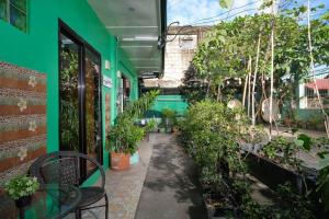 Golden V Executive Homes Unit H في Malolos: مبنى أخضر مع فناء بالنباتات