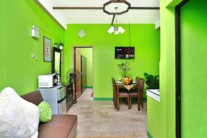 a kitchen with green walls and a table in a room at Golden V Executive Homes Unit H in Malolos