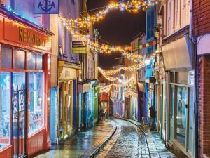 an empty street with christmas lights in an alley at Seaside serenity in our charming 1-bedroom retreat in Kent