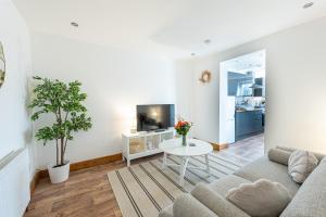 a living room with a couch and a table at Seaside serenity in our charming 1-bedroom retreat in Kent