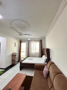 a living room with a bed and a couch at Rainbow apartment in Mombasa