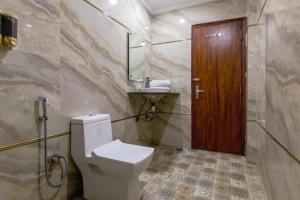 baño con aseo y puerta de madera en Hotel NEU Villa Newly Built New Delhi, en Nueva Delhi