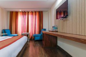 Habitación de hotel con 1 cama y 2 sillas azules en Hotel NEU Villa Newly Built New Delhi, en Nueva Delhi