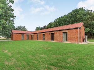 a brick building with a large grass field at Partridge in East Ilsley