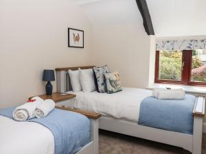 a bedroom with two beds and a window at Nempnett Farmhouse in Bristol