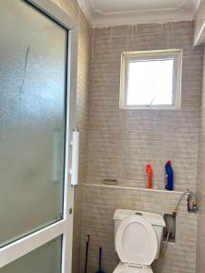 a bathroom with a toilet and a window at Rainbow apartment in Mombasa