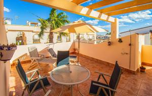 eine Terrasse mit Tisch und Stühlen und einem Sonnenschirm in der Unterkunft 2 Bedroom Nice Home In La Florida in La Florida