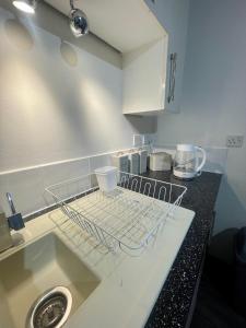 a kitchen with a dish drying rack on the counter at The Home Away From Home in Great Harwood