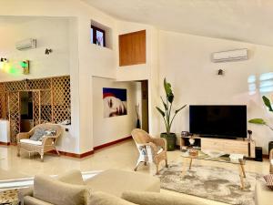 sala de estar con TV, sofá y sillas en Villa Ottavia, en Noto
