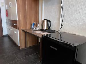 eine Mikrowelle, die auf einem Tisch in einem Zimmer steht in der Unterkunft Hotel Filoxenia in Butjadingen