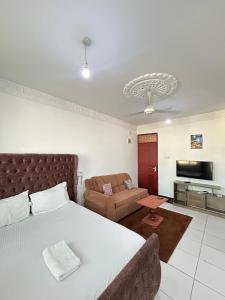 a bedroom with a bed and a living room at Rainbow apartment in Mombasa