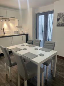 a white table and chairs in a kitchen at The Home Away From Home in Great Harwood
