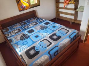 a bed with a blue comforter on top of it at Villa Baobab in Tôlagnaro