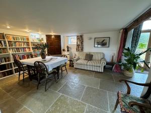 a living room with a table and chairs and a couch at Unique 17c listed Barn in a Shropshire hamlet. in Albrighton