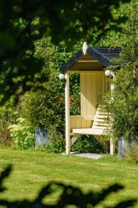 a gazebo with a bench in a yard at Penbontbren Luxury Bed and Breakfast in Aberporth