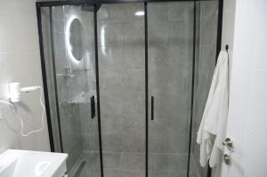 La salle de bains est pourvue d'une douche avec une porte en verre. dans l'établissement BY KARAM SUİT, à Istanbul