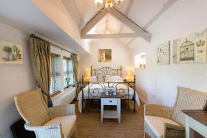 a bedroom with a bed and two chairs and a table at Penbontbren Luxury Bed and Breakfast in Aberporth