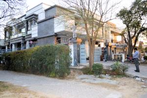 a man standing in front of a house at Rose Valet Guest House in Islamabad