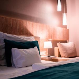 Un dormitorio con una cama con una almohada verde y blanca en The Hotel Unforgettable - Hotel Tiliana by Homoky Hotels & Spa en Budapest