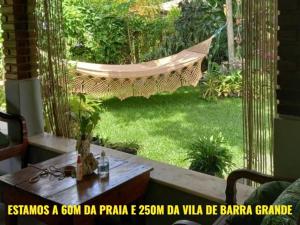 a hammock in a backyard with a hammock in a yard at Coroaci Beach House in Barra Grande