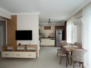a kitchen and dining room with a table and a television at VİLLA BLUE CRAB in Ortaca