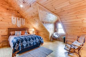 a bedroom with a bed in a log cabin at Spacious Howard Cabin with Wraparound Deck and Views! 