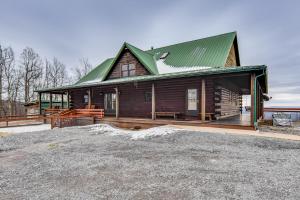 een blokhut met een groen dak op veel bij Spacious Howard Cabin with Wraparound Deck and Views! 